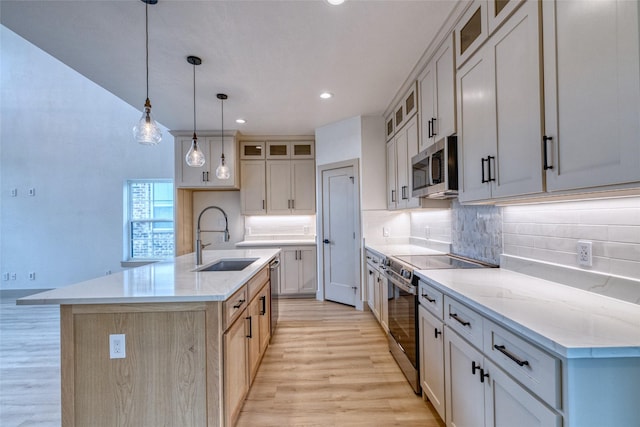 6 Rio Seco Dr, Uvalde, TX 78801 - kitchen with stainless steel appliances, light wood-style flooring, decorative backsplash, a center island with sink, and recessed lighting
