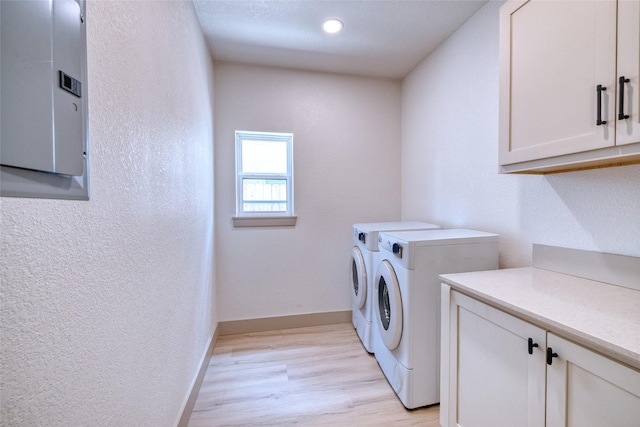 6 Rio Seco Dr, Uvalde, TX 78801 - laundry room with washer and dryer, cabinet space, electric panel, a textured wall, and light wood-type flooring