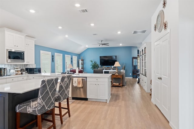 4236 Waterlily Spring Way, Porter, TX 77365 - kitchen with appliances with stainless steel finishes, a ceiling fan, a peninsula, light countertops, and light wood-style floors