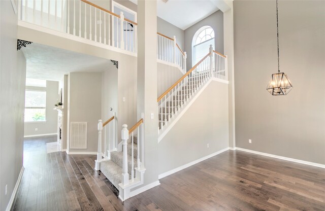 19927 Maple Village Dr, Cypress, TX 77433 - stairway with wood finished floors, a chandelier, a towering ceiling, and baseboards