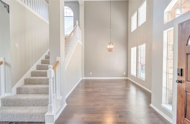 19927 Maple Village Dr, Cypress, TX 77433 - foyer featuring a towering ceiling, dark wood-type flooring, stairway, baseboards, and a chandelier