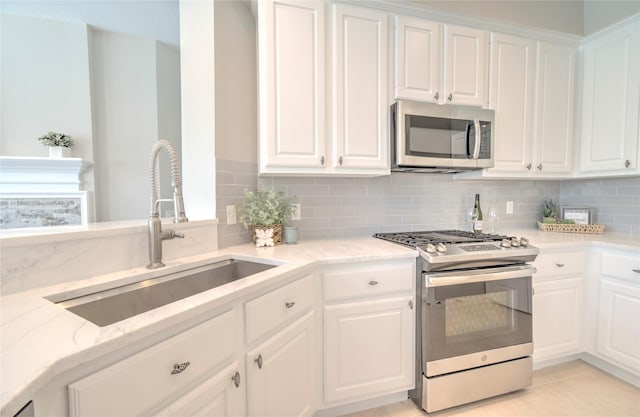 19927 Maple Village Dr, Cypress, TX 77433 - kitchen with stainless steel appliances, a sink, tasteful backsplash, and white cabinetry