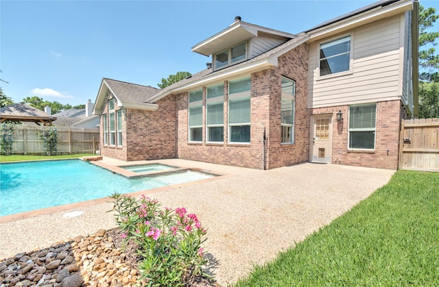 19927 Maple Village Dr, Cypress, TX 77433 - back of property featuring brick siding, a patio area, a fenced backyard, and a pool with connected hot tub