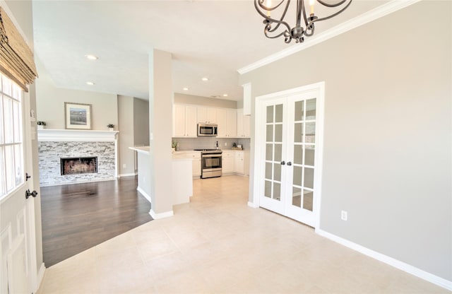 19927 Maple Village Dr, Cypress, TX 77433 - kitchen featuring stainless steel appliances, french doors, open floor plan, ornamental molding, and white cabinetry