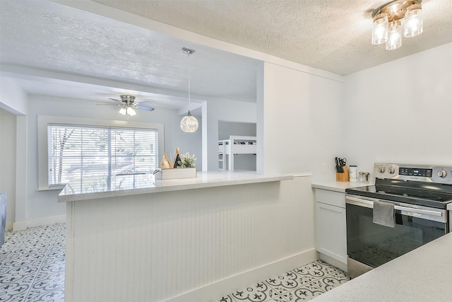 1513 19th St, Galveston, TX 77550 - kitchen featuring stainless steel electric range, baseboards, light countertops, a textured ceiling, and a ceiling fan