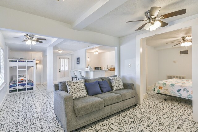 1513 19th St, Galveston, TX 77550 - living room featuring ceiling fan, baseboards, and beam ceiling
