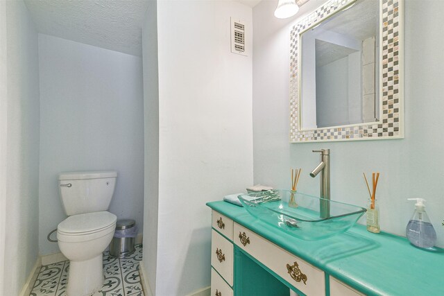 1513 19th St, Galveston, TX 77550 - half bathroom featuring baseboards, toilet, vanity, and tile patterned flooring