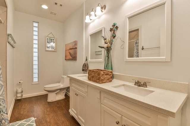 1513 19th St, Galveston, TX 77550 - full bathroom featuring double vanity, wood finished floors, toilet, and healthy amount of natural light