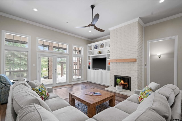 420 Bunker Dr, Tyler, TX 75703 - living room featuring crown molding, a brick fireplace, wood finished floors, ceiling fan, and recessed lighting