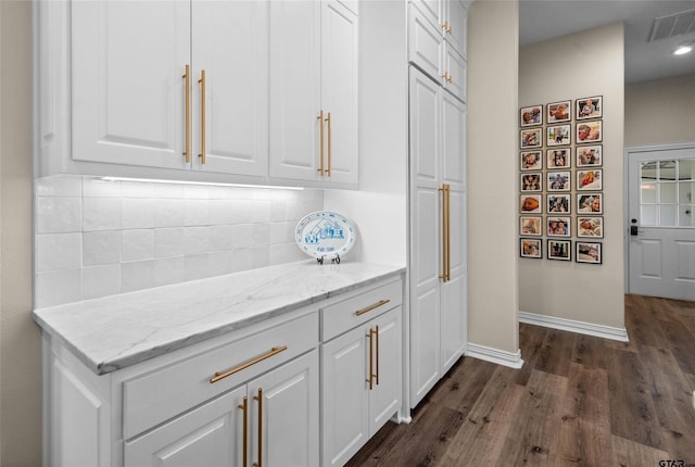 420 Bunker Dr, Tyler, TX 75703 - kitchen featuring dark wood-style floors, backsplash, white cabinetry, baseboards, and light stone counters