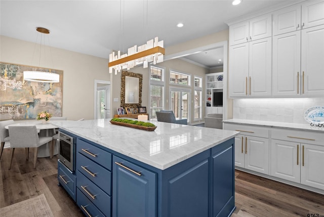 420 Bunker Dr, Tyler, TX 75703 - kitchen with blue cabinets, white cabinets, dark wood finished floors, a kitchen island, and decorative backsplash