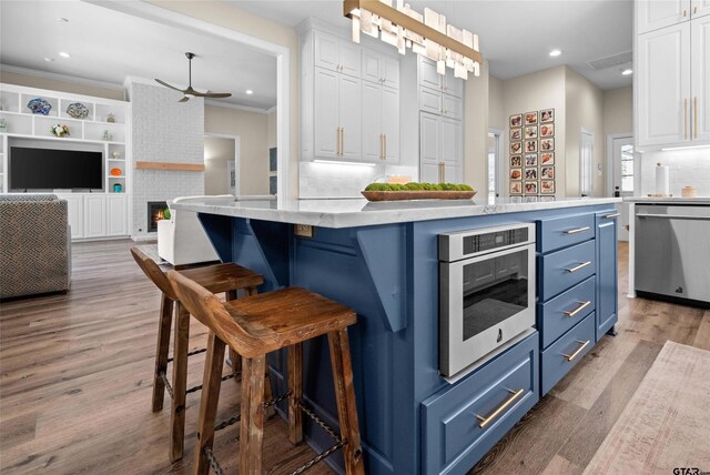 420 Bunker Dr, Tyler, TX 75703 - kitchen with blue cabinets, dishwasher, white cabinets, ceiling fan, and wood finished floors