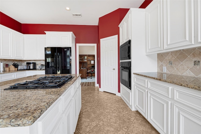 2005 Mistwood Ct, Pearland, TX 77584 - kitchen featuring black appliances, backsplash, white cabinetry, light tile patterned floors, and light stone counters