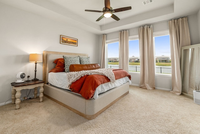 77 Indian Wells Dr, Manvel, TX 77578 - bedroom with carpet floors, baseboards, a raised ceiling, a water view, and ceiling fan