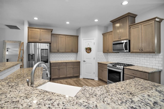 4142 Longhorn Dr, Cleveland, TX 77328 - kitchen featuring stainless steel appliances, light wood-style flooring, recessed lighting, ceiling fan, and decorative backsplash