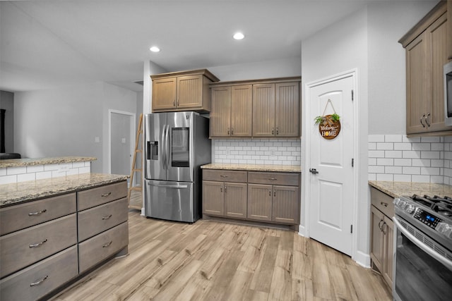 4142 Longhorn Dr, Cleveland, TX 77328 - kitchen featuring stainless steel appliances, tasteful backsplash, light wood-type flooring, recessed lighting, and light stone countertops