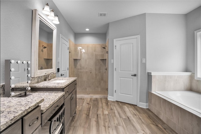 4142 Longhorn Dr, Cleveland, TX 77328 - full bathroom featuring a stall shower, a garden tub, vanity, wood finished floors, and recessed lighting