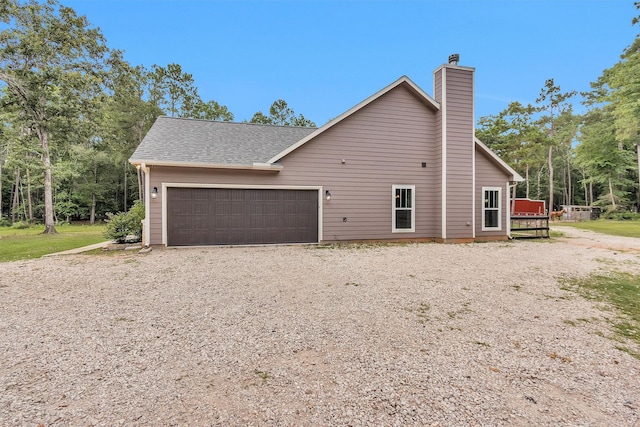 4142 Longhorn Dr, Cleveland, TX 77328 - view of home's exterior with an attached garage, a chimney, driveway, and a shingled roof