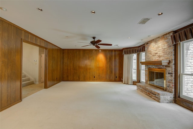 5311 Graystone Ln, Houston, TX 77069 - unfurnished living room featuring wood walls, healthy amount of natural light, light colored carpet, a ceiling fan, and stairs