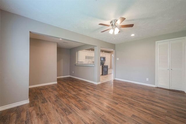3915 Florinda St, Houston, TX 77021 - unfurnished living room with a ceiling fan, baseboards, dark wood finished floors, a sink, and recessed lighting