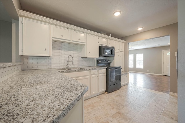 3915 Florinda St, Houston, TX 77021 - kitchen featuring black appliances, a sink, tasteful backsplash, white cabinetry, and recessed lighting