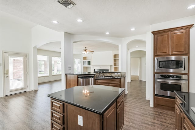 22011 Twinkle Sky Ct, Cypress, TX 77433 - kitchen featuring stainless steel appliances, a sink, arched walkways, a center island, and a textured ceiling