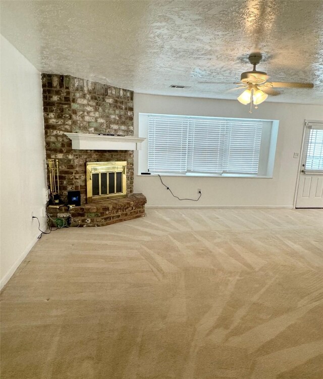 28811 Enchanted Dr, Shenandoah, TX 77381 - unfurnished living room with a textured ceiling, ceiling fan, carpet floors, a fireplace, and baseboards