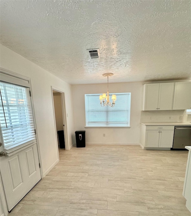 28811 Enchanted Dr, Shenandoah, TX 77381 - unfurnished dining area featuring a textured ceiling, a chandelier, light wood-style floors, plenty of natural light, and baseboards