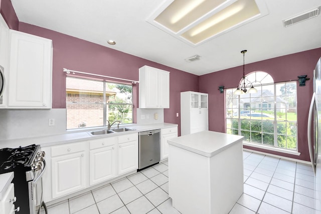 7115 Blanco Pines Dr, Humble, TX 77346 - kitchen featuring appliances with stainless steel finishes, a sink, light countertops, a center island, and white cabinetry