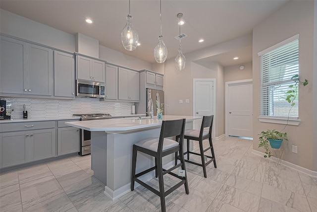 24227 Tallgrass Meadow Trl, Katy, TX 77493 - kitchen with gray cabinetry, stainless steel appliances, decorative backsplash, light marble finish flooring, and light countertops