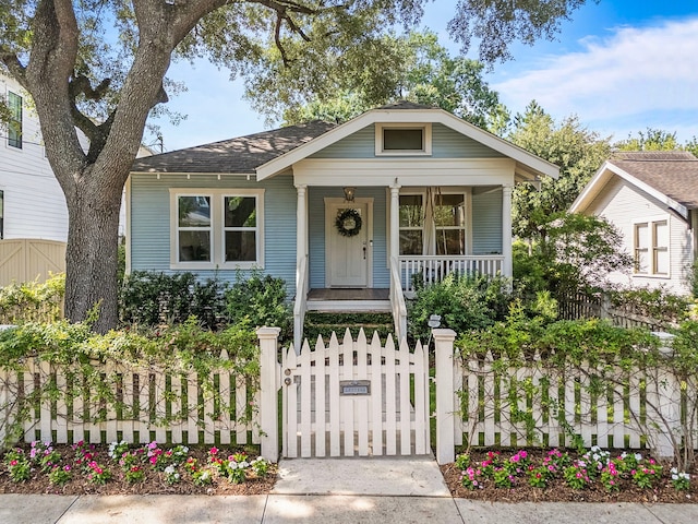 714 Merrill St, Houston, TX 77009 - bungalow-style home with a porch, a fenced front yard, and a gate