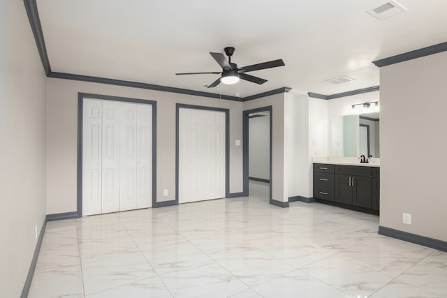 11835 S Ridgewood Cir, Houston, TX 77071 - unfurnished bedroom featuring baseboards, light marble finish flooring, ornamental molding, two closets, and a sink
