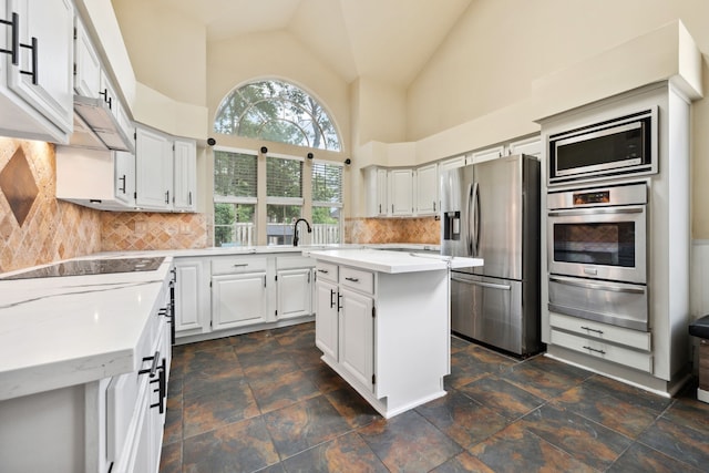 16418 Willowpark Dr, Tomball, TX 77377 - kitchen with stainless steel appliances, a warming drawer, a kitchen island, high vaulted ceiling, and backsplash