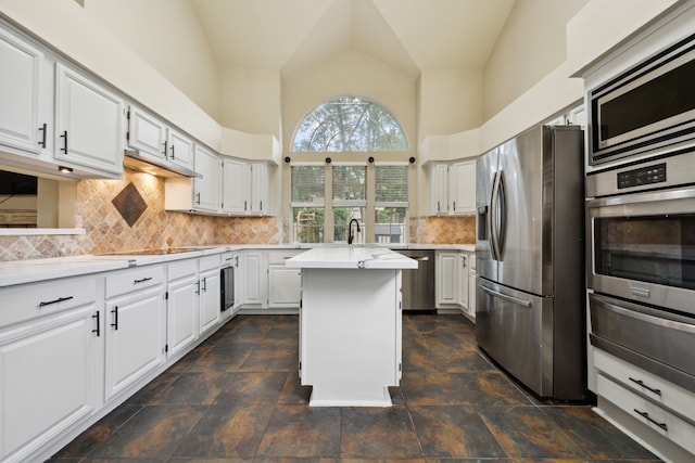 16418 Willowpark Dr, Tomball, TX 77377 - kitchen with stainless steel appliances, a warming drawer, light countertops, a center island, and white cabinets