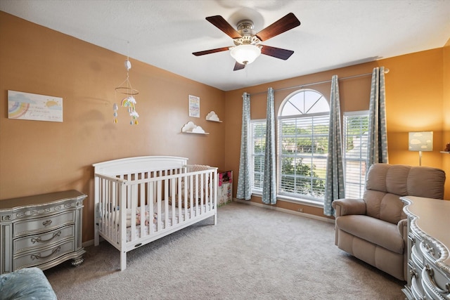 16418 Willowpark Dr, Tomball, TX 77377 - bedroom featuring carpet floors, a crib, ceiling fan, and baseboards