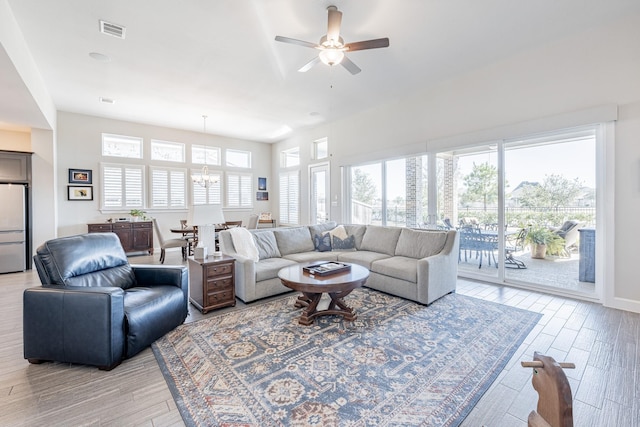 30411 Indigo Falls Dr, Brookshire, TX 77423 - living area with light wood-style floors, a ceiling fan, and a chandelier