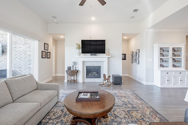 30411 Indigo Falls Dr, Brookshire, TX 77423 - living room with ceiling fan, wood finished floors, a glass covered fireplace, baseboards, and crown molding