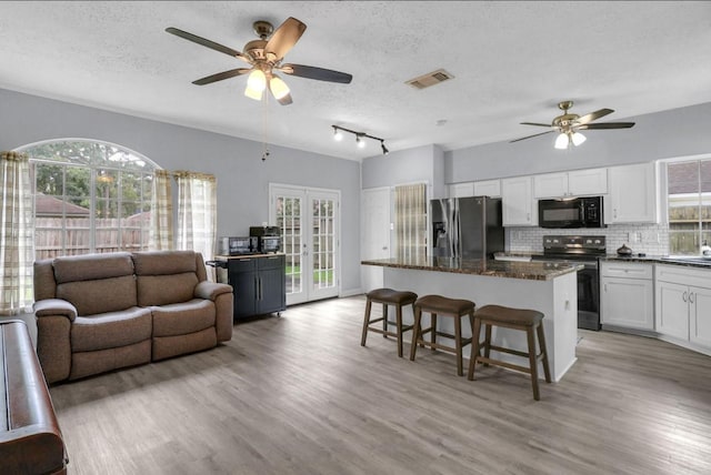 5418 Forest Springs Dr, Houston, TX 77339 - kitchen featuring electric stove, black microwave, stainless steel fridge with ice dispenser, a ceiling fan, and a textured ceiling