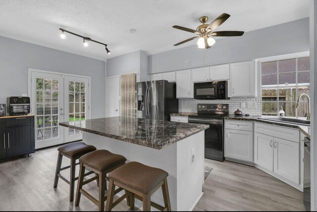 5418 Forest Springs Dr, Houston, TX 77339 - kitchen featuring black appliances, decorative backsplash, french doors, light wood-type flooring, and a ceiling fan