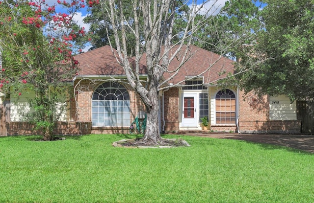 5418 Forest Springs Dr, Houston, TX 77339 - view of front of house featuring brick siding, a front yard, and a shingled roof