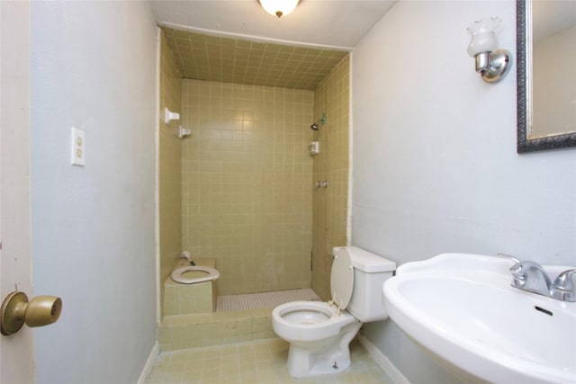 4604 Octavia St, Houston, TX 77026 - full bath featuring a sink, a stall shower, toilet, baseboards, and tile patterned flooring