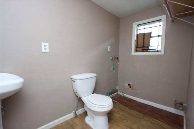 4604 Octavia St, Houston, TX 77026 - bathroom featuring toilet, wood finished floors, and baseboards
