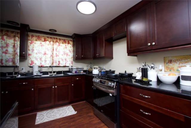 4604 Octavia St, Houston, TX 77026 - kitchen with gas stove, dark wood-style floors, dark countertops, and a sink