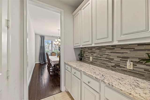 6 Volerran Path Ln, Missouri City, TX 77459 - kitchen featuring a chandelier, backsplash, light wood-style flooring, white cabinetry, and light stone counters