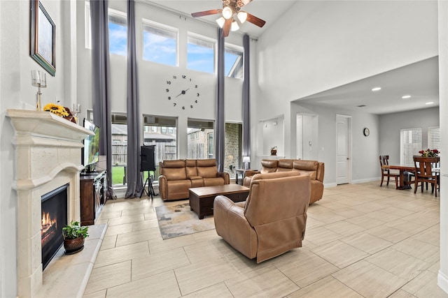 6 Volerran Path Ln, Missouri City, TX 77459 - living area featuring ceiling fan, a high end fireplace, a towering ceiling, and baseboards