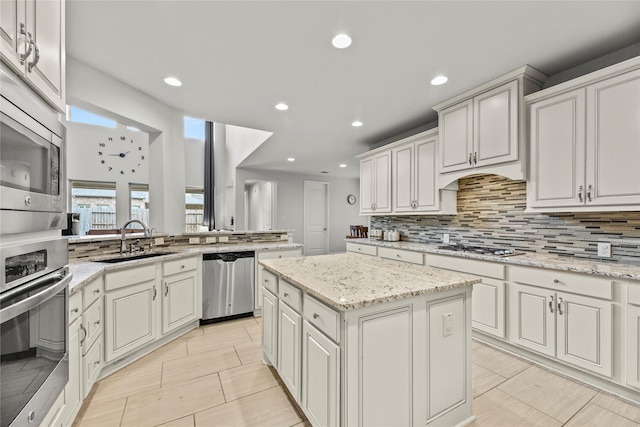 6 Volerran Path Ln, Missouri City, TX 77459 - kitchen with stainless steel appliances, decorative backsplash, a sink, recessed lighting, and a center island