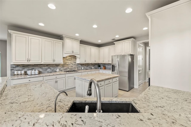6 Volerran Path Ln, Missouri City, TX 77459 - kitchen featuring appliances with stainless steel finishes, a sink, backsplash, light stone counters, and recessed lighting