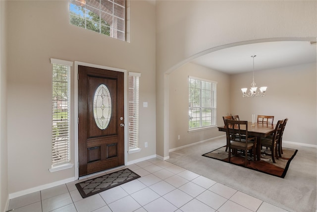3610 Harewood Ct, Pearland, TX 77584 - entrance foyer with a chandelier, arched walkways, light tile patterned floors, baseboards, and a towering ceiling