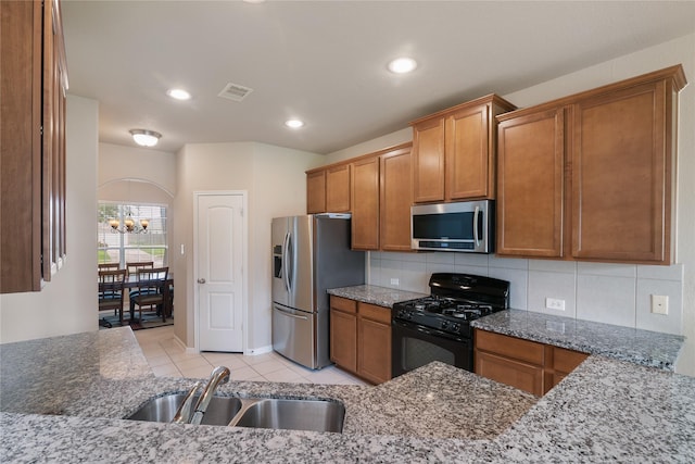 3610 Harewood Ct, Pearland, TX 77584 - kitchen with stainless steel appliances, a sink, brown cabinets, light tile patterned flooring, and stone countertops