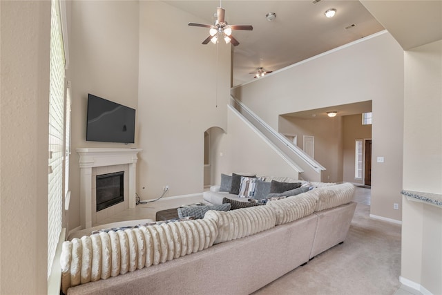 3610 Harewood Ct, Pearland, TX 77584 - living area featuring ceiling fan, stairway, a fireplace, a towering ceiling, and light carpet